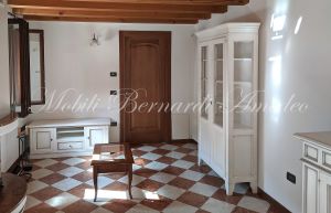 Vetrina in legno stile country con altri mobili da soggiorno e cucina nello stesso stile e finitura